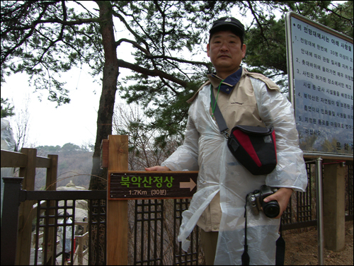 북악산 정상까지 30분이라는 팻말을 가리키며 빠른 시일 내에 전구간이 개방되면 좋겠다는 유두희씨 